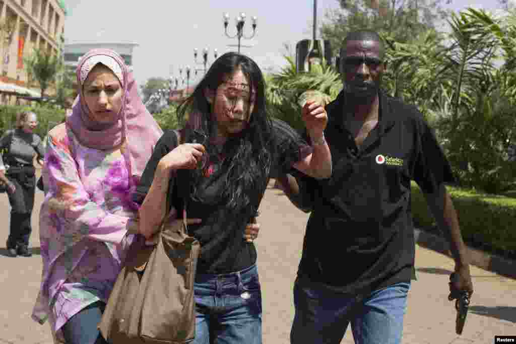 An injured woman is helped out of the Westgate shopping center after the shooting spree on September 21.