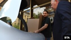  Алекбер Абил от младежкото Движение за права и свободи изнася кашони от постройката, 19 май 2025 година 