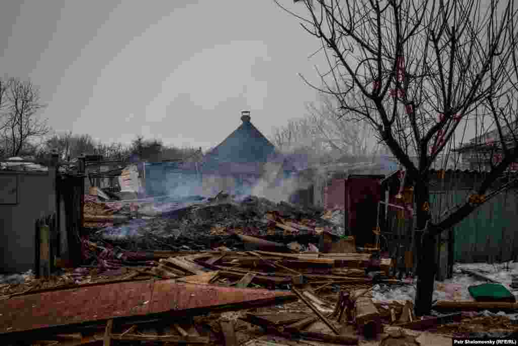 Smoke rises from the rubble of houses destroyed by shelling.