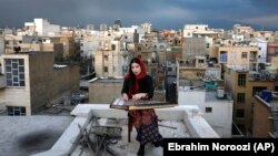 مژگان حسینی، نوازنده ۲۸ ساله قانون، بر بام خانه‌اش در تهران