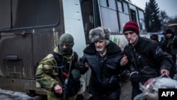 An elderly Ukrainian man is helped by a Ukrainian Army soldier and a citizen during the evacuation of civilians in Debaltseve, in the Donetsk region, on February 3.