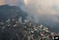 O vedere aeriană a satului Sirtkoy, cuprins de flăcări, în apropierea localității Manavgat. Peste 100 de incendii au fost aduse sub control în Turcia, potrivit oficialilor.