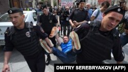 Российские полицейские уносят ЛГБТ-активиста Николая Алексеева, участвовавшего в несанкционированной акции протеста в поддержку прав секс-меньшинств. Москва, 30 мая 2015 года.