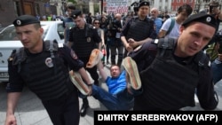 Russian riot police detain an LGBT rights activist during a rally in central Moscow in 2015.