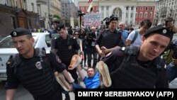 Russian riot police detain gay rights activist Nikolai Alekseyev during an unauthorized gay-rights rally in central Moscow in May.