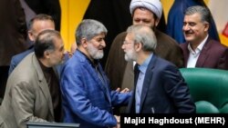 Iranian Parliament speaker Ali Larijani (2nd R) shaking hand with his second deputy Ali Motahari, May 31, 2017.