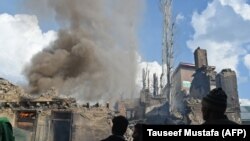 Kashmiri villagers watches a house on fire following a deadly gun battle between militants and Indian government forces in the Tral area of Pulwama district, south of Srinagar, on March 5.