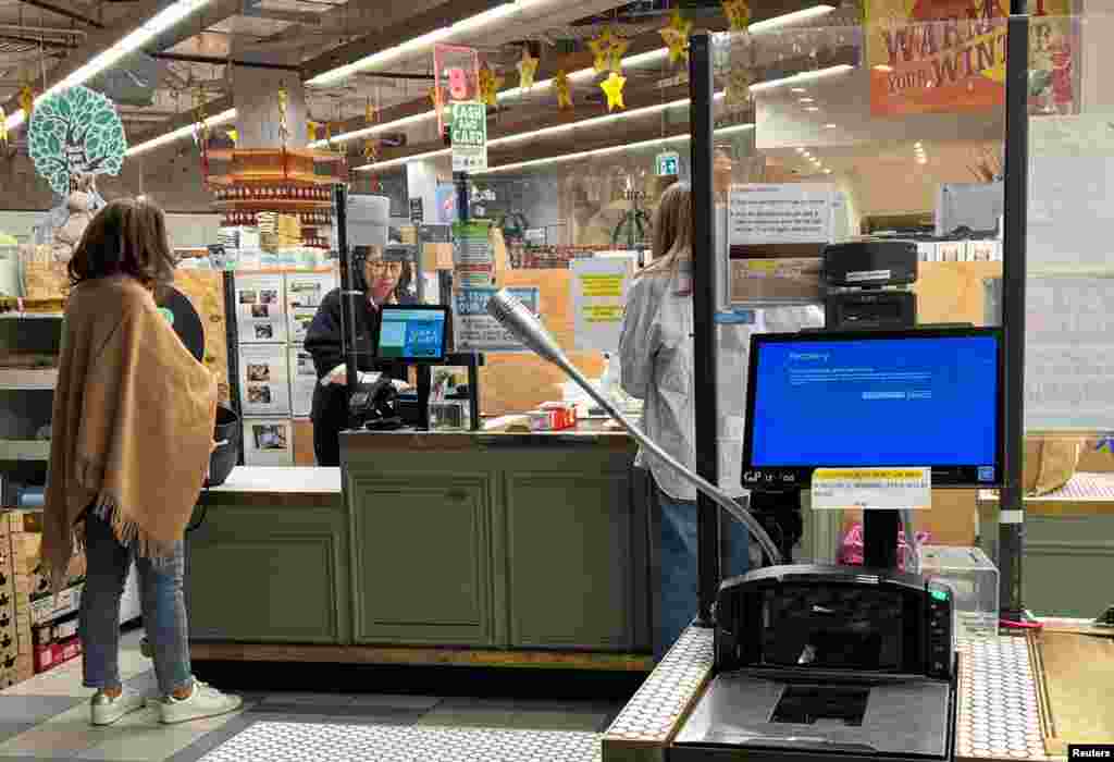 A cash register shows a blue screen at a grocery store in Sydney. Services slowly started coming back online after hours of disruption. &nbsp;