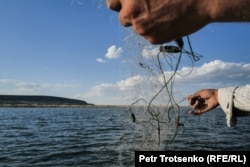 Nurzhan casts a fishing net