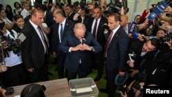 Armenian Prime Minister Nikol Pashinian gives his signature "heart" symbol as he casts his vote.