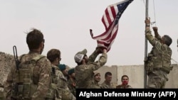 U.S. troops take down their country's flag as part a ceremony held to hand over an American base to local defense forces in May. Afghanistan was overrun by the Taliban just a few months later, shortly before the United States had fully completed its withdrawal. 