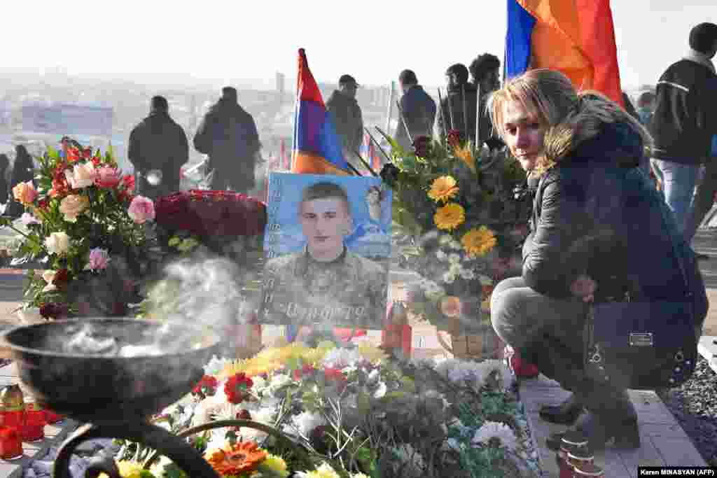 A woman at the grave of a young soldier at Yerablur cemetery on December 19