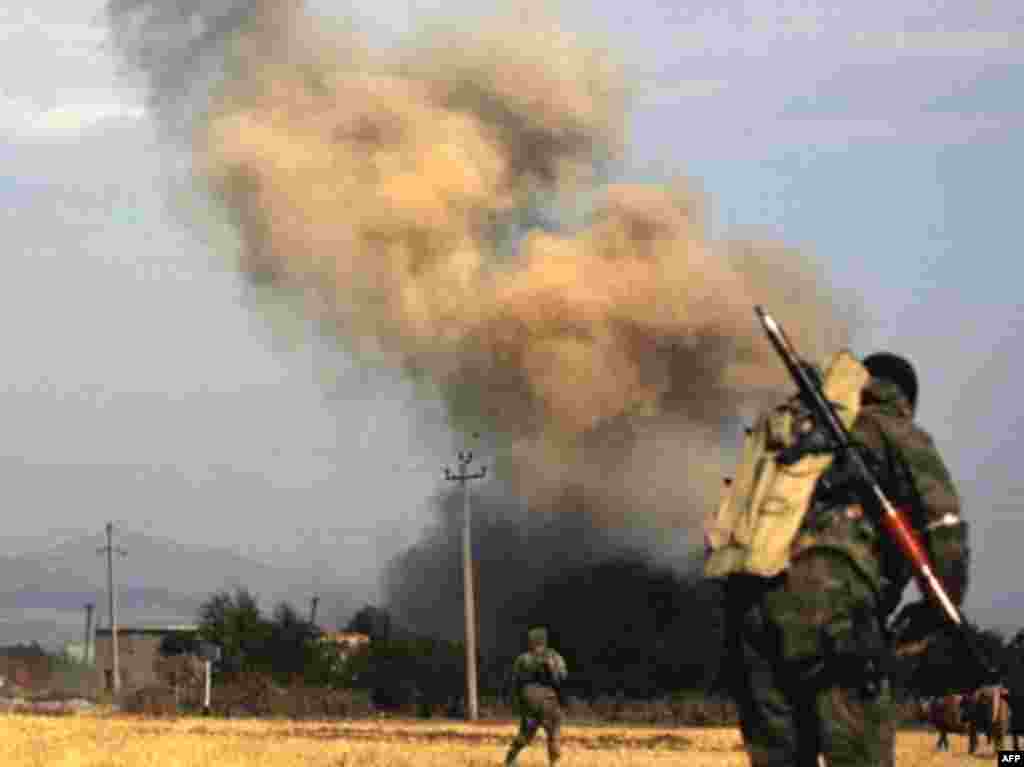 GEORGIA, ZEMO NIKOZI : Russian soldiers run on August 11, 2008 in the village of Zemo Nikozi, some 15 kilometers from Tskhinvali. During clashes with Georgian troops in the area, four Russian soldiers were killed. Georgia on August 11 resumed aerial and artillery bombardment of Tskhinvali, the main town in South Ossetia,