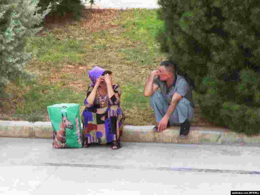 Köçäniň gyrasynda dynç alyp, söhbet edýän adamlar