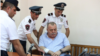 Armenia -- Police officers help General Manvel Grigorian during his trial in Yerevan.