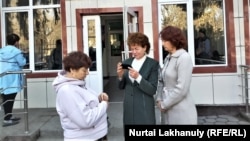 Galina Arzamasova (center) stands outside the Talghar district court on March 17.