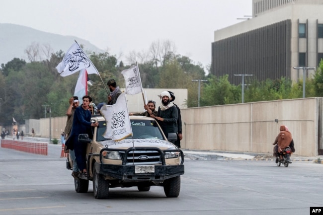 Taliban fighters carrying flags as they celebrate the fourth anniversary of their 2021 takeover of Afghanistan, in Kabul on August 15.