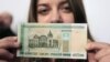 A woman holds a new 200,000 Belarusian ruble note (approximately $24.48) during a presentation to the media in Minsk on March 12.