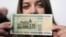 A woman holds a new 200,000 Belarusian ruble note (approximately $24.48) during a presentation to the media in Minsk on March 12.