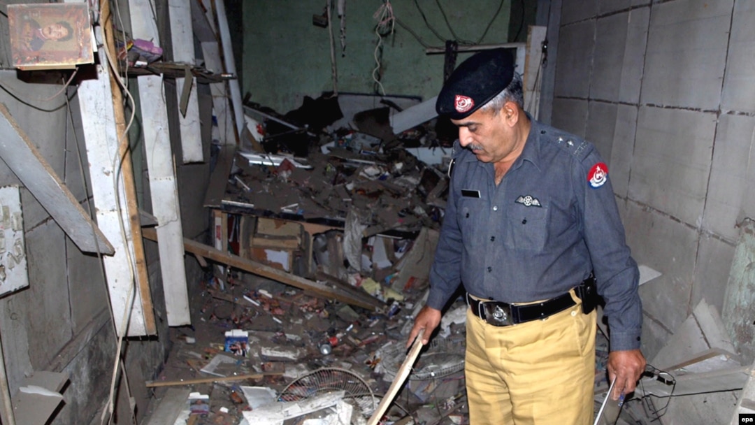 A police official inspects a damaged music shop after a bomb explosion in Charsadda, a town in the Northwest Frontier Province, in 2009.