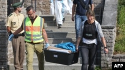 Police officers leave after conducting a search at a refugee shelter on July 25 where a 27-year-old Syrian migrant who set off an explosive device near an open-air music festival had stayed, in Ansbach.