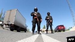 Ukrainian special forces officers stand guard at a checkpoint on the road between Donetsk and Slovyansk on April 25.