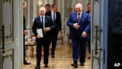 Russian President Vladimir Putin (left) and Belarusian President Alyaksandr Lukashenka emerge after talks at the Palace of Independence in Minsk on May 24.