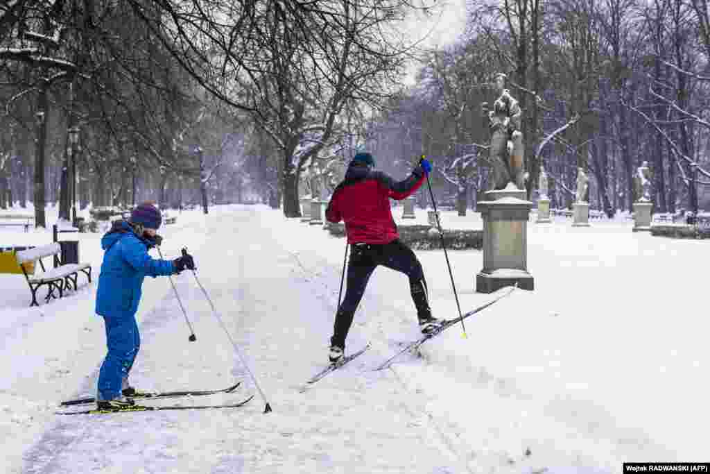 Польща. Батько та син на лижах у засніженому парку в центрі Варшави, 10 лютого 2021 року