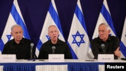 Kryeministri izraelit Benjamin Netanyahu (majtas), ministri i Mbrojtjes, Yoav Gallant (në mes), dhe ministri i kabinetit Benny Gantz, në një konferencë shtypi në bazën ushtarake Kirya në Tel Aviv, Izrael, më 28 tetor 2023.