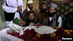 Supporters and family members of Mumtaz Qadri sit near his body after his execution in Rawalpindi, Pakistan, on February 29. Qadri was hanged for murdering a provincial governor in 2011 after the official called for reform of the country's strict blasphemy laws.