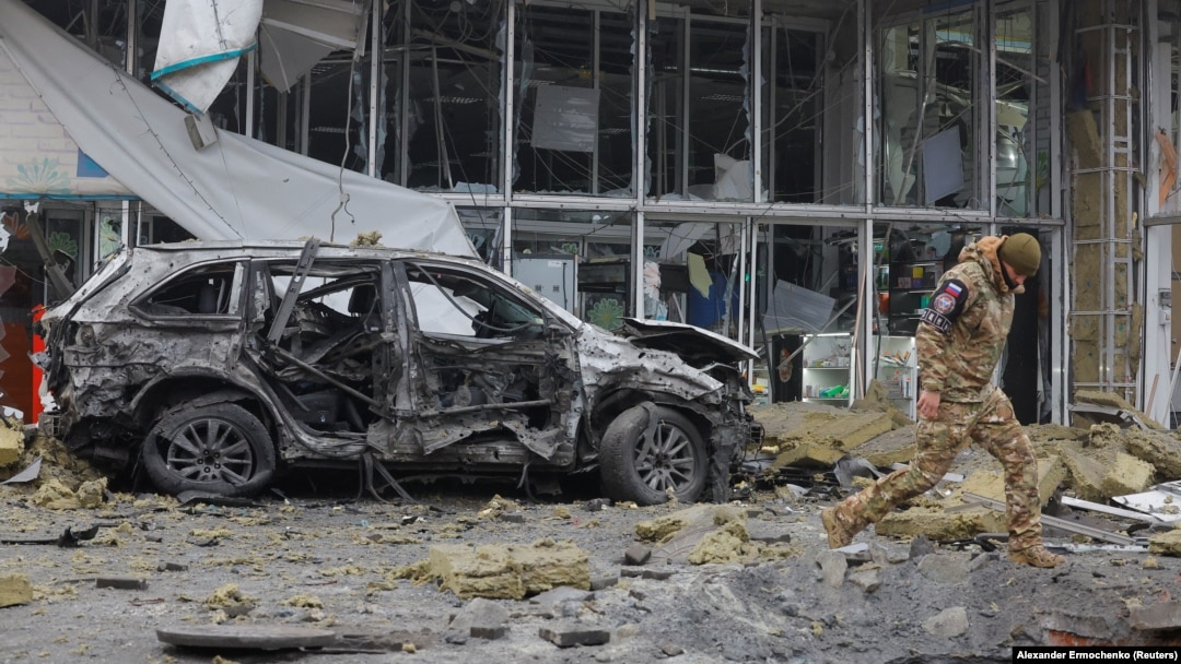 La 10 ianuarie, un anchetator se plimbă pe lângă un magazin avariat în urma bombardamentelor din orașul ocupat Donețk, pe care autoritățile locale instalate în Rusia le-au numit un atac militar ucrainean. 