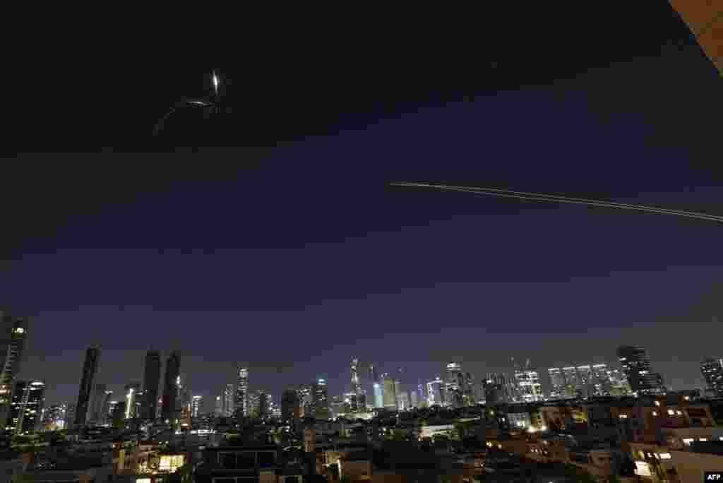 Dâre luminoase de rachete sunt vizibile pe cer în timpul unui nou baraj de atacuri cu rachete iraniene deasupra orașului israelian Tel Aviv, pe 3 martie 2026. 