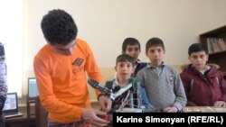 Vazgen Hovhannisian (left), a 16-year-old computer-game designer, works on a robot during a computer club meeting in the Armenian village of Aygek. 