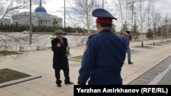 "Әкімдік жерімді заңсыз тартып алды" деп өзін Ақорда алдында өртейтінін айтқан Қуат Шәріпханов полициямен әңгімелесіп тұр. Нұр-Сұлтан, 23 сәуір 2019 жыл. 