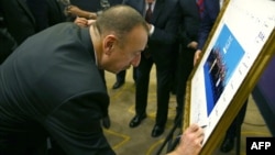 Turkey -- Azerbaijani President Ilham Aliyev signs a print of the G20-Turkey family photo at the Group of 20 (G20) summit, in the Mediterranean resort city of Antalya, November 15, 2015