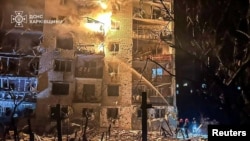 Firefighters work at the site of the apartment building hit by a Russian missile strike in the city of Balakliya, Kharkiv region, Ukraine, early on November 17.