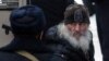 Father Sergy is escorted to a court in Moscow on December 29, 2020.