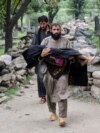 A man in Afghanistan's Kunar Province carries a young victim of an August 31 earthquake that killed many people and destroyed several villages. 