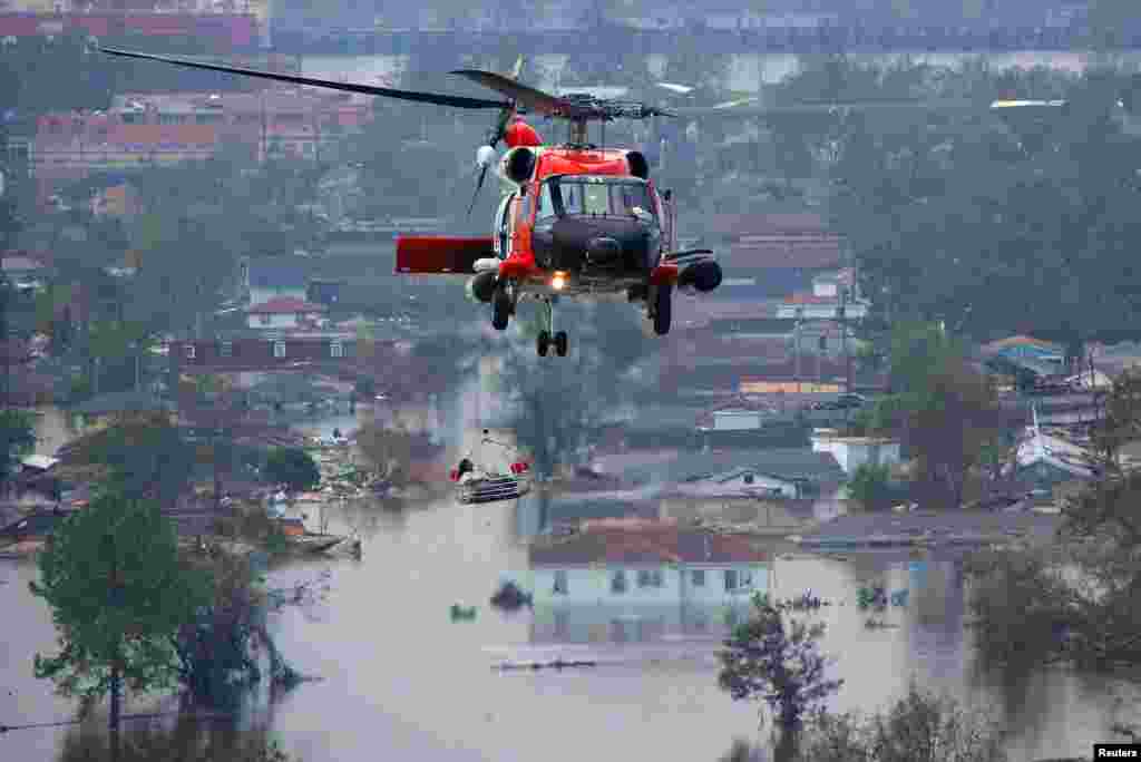 A helicopter crew helps a resident flee a flooded neighborhood on August 30.