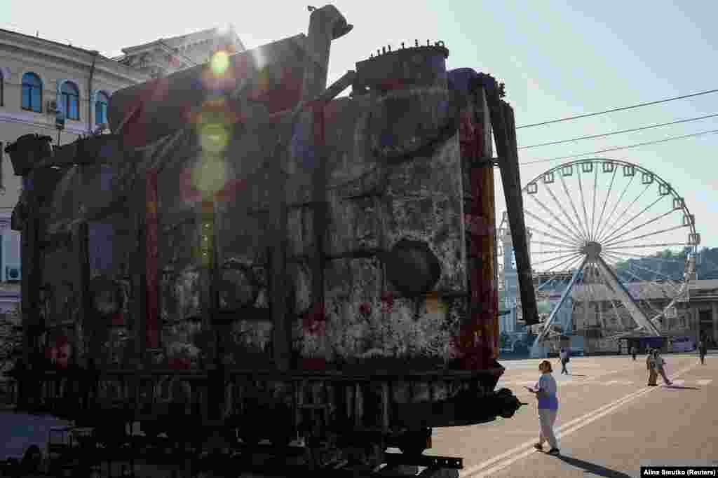 A woman looks at an installation with a power transformer, damaged by a Russian military strike in central Kyiv.