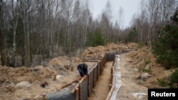 Робітник будує траншею в рамках системи нових фортифікаційних ліній біля російського кордону в Чернігівській області. Фото ілюстративне 