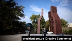 Ukrainian President Volodymyr Zelenskiy (left) and Crimean Tatar leader Mustafa Dzhemilev speak at the memorial's opening ceremony in Kyiv on September 11.