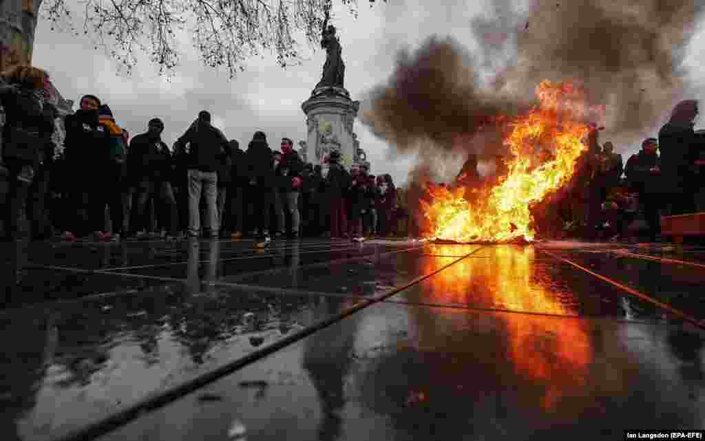 A trashcan burns on Place de la Republique as students demonstrate against the increase of the subscription fees for foreign students in Paris on December 7. (EPA-EFE/Ian Langsdon)