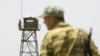 A Tajik guard stands on a bridge to Afghanistan across the Panj River at the Panji Poyon border outpost. (file photo)