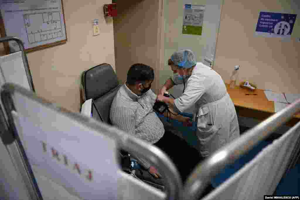 MOLDOVA - O asistentă medicală măsoară tensiunea arterială a unui membru al personalului medical înainte de a fi vaccinat împotriva COVID-19 la &bdquo;Institutul de Urgență&rdquo; din capitala Moldovei Chișinău la 24 martie 2021.