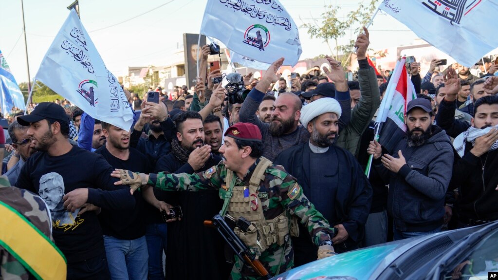 شبه‌نظامیان حشد الشعبی در مراسم تشییع جنازه یکی از فرماندهان گروه کتائب حزب‌الله که در حملهٔ هوایی آمریکا در بغداد کشته شد، ۱۹ بهمن