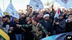 شبه‌نظامیان حشد الشعبی در مراسم تشییع جنازه یکی از فرماندهان گروه کتائب حزب‌الله که در حملهٔ هوایی آمریکا در بغداد کشته شد، ۱۹ بهمن