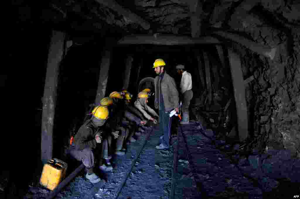 Miners wait to remove the bodies of their colleagues from the mine.