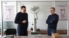 Vladimir Melnic (stânga), vicedirector la Centrul Național Tehnologii Spațiale de la UTM și Alexei Martîniuc, cercetător științific, discutând pe fundalul prototipului unui satelit lansat anterior în spațiu.