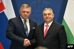 Premierul slovac Robert Fico (s) și omologul său maghiar Viktor Orban își strâng mâna la o conferință de presă la mănăstirea Carmelita, pe 16 ianuarie 2024, după discuțiile oficiale.